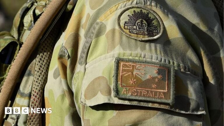 Australian soldier killed and five injured in crash during training exercise Close-up of the shoulder insignia of an Australian soldier wearing a combat uniform