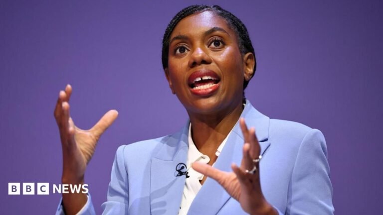 Battle of ideas looming in British politics, Badenoch to say Kemi Badenoch speaking while wearing a light blue suit and white shirt. She's gesticulating with her hands as she speaks.