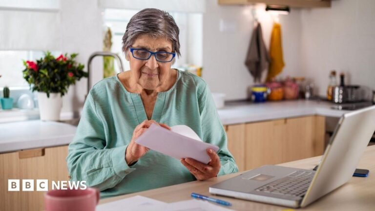 Bereaved families will not face tax bill over pension delays under new rules A woman sitting in front of a laptop opens a letter.