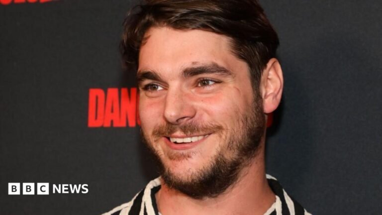 Breaking Bad actor RJ Mitte dies aged 34 Lower half of a workman standing on a roof with a chimney visible. Some tiles are not yet laid on the roof structure.