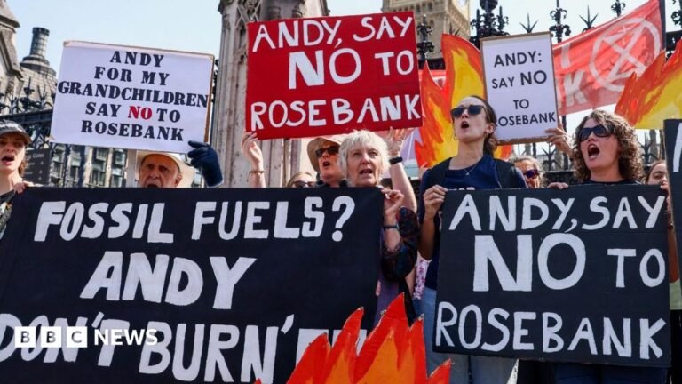 Burnham warned Rosebank oil field could breach West Bank sanctions Protesters outside Parliament in central London hold placards reading "Andy, say no to Rosebank" and drawings of flames.