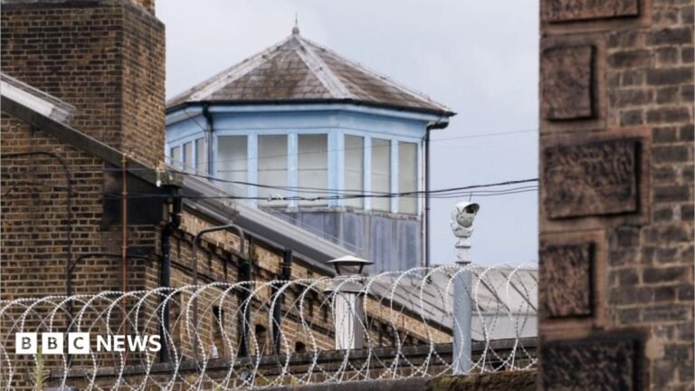 Criminals who skip sentencing will face solitary confinement or lose social visits Somebody holding up a smart-phone in their right hand. The screen is black with 'Revolut' written in white letters.