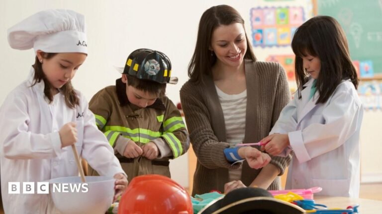 Employers should teach primary-age children about work, Milburn says Three young children of primary school age are dressed up as a chef, a fireman and a nurse alongside their teacher in a classroom setting.