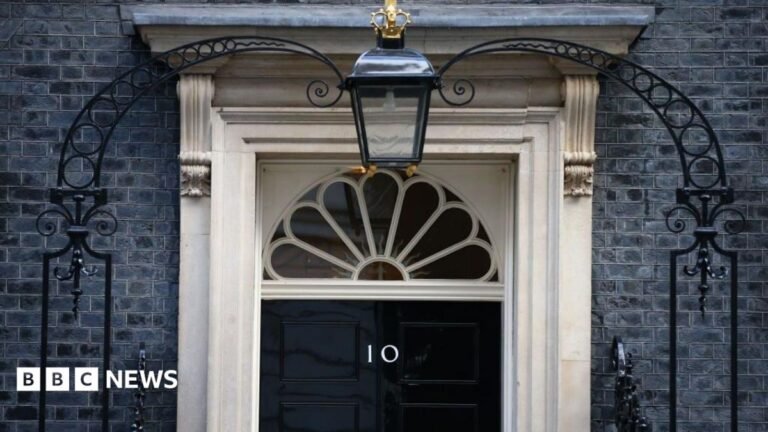 Keir Starmer’s government discussed moving out of 10 Downing Street Andy Burnham walks along the pavement in Downing Street in front of the exterior wall and the black Number 10 door.