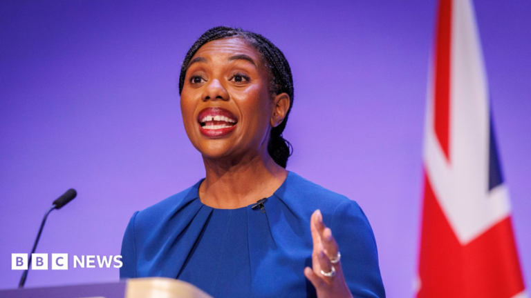 Kemi Badenoch says Tories would scrap inheritance tax on family homes Hamish Badenoch and Kemi Badenoch are surrounded by Tory members, some of whom are holding tiny miniature Union flags. Hamish and Kemi Badenoch are both waving. Hamish is wearing a dark-coloured suit, white shirt and blue tie, while Kemi is wearing a blue dress.