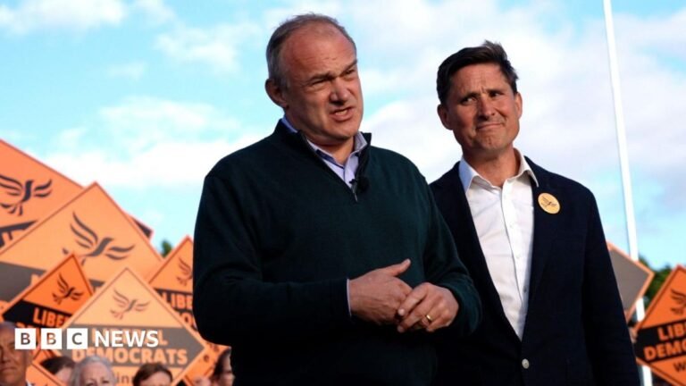 Lib Dem MP quits frontbench job over Ed Davey’s leadership Ed Davey standing next to Charlies Maynard in front of supporters holding several orange Lib Dem placards