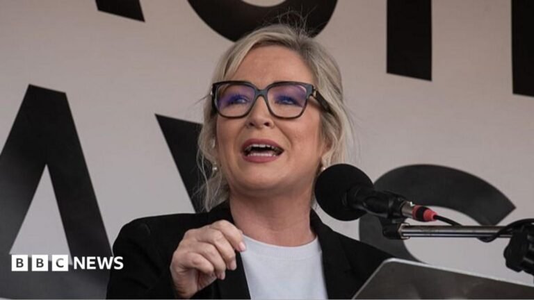 Michelle O’Neill rejects call to resign over Drumcree row Michelle O'Neill speaking in the NI Assembly. She has blonde hair, wearing glasses, a black blazer and white shirt. Other Sinn Fein MLAs are sitting behind her.