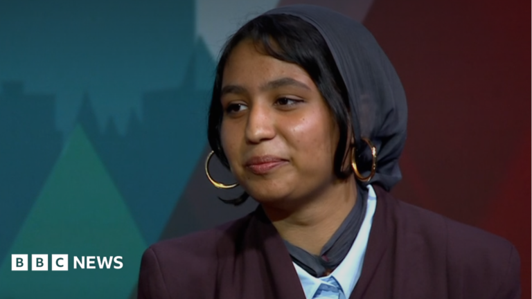 Money is tight but don’t axe Youth Parliament, says Essex member A head and shoulders image of a young woman wearing a purple blazer over a light blue shirt, gold hoop earrings and a headscarf.