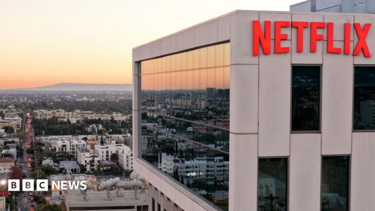 Netflix to lay off 1,000 staff in steepest cuts since 2022 MI5 chief Sir Ken McCallum has short dark hair, dark glasses and is wearing a dark suit with a green tie.