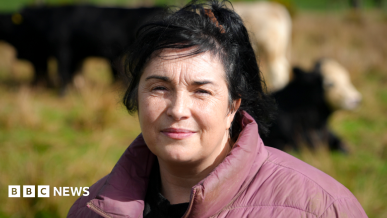 Powys farmer says abuse from dad was ‘torture’ and wants more support A headshot of farmer Tracy Lewis. She has black hair and wears a red coat with a black t-shirt. In the background, black and white cows are in a green field