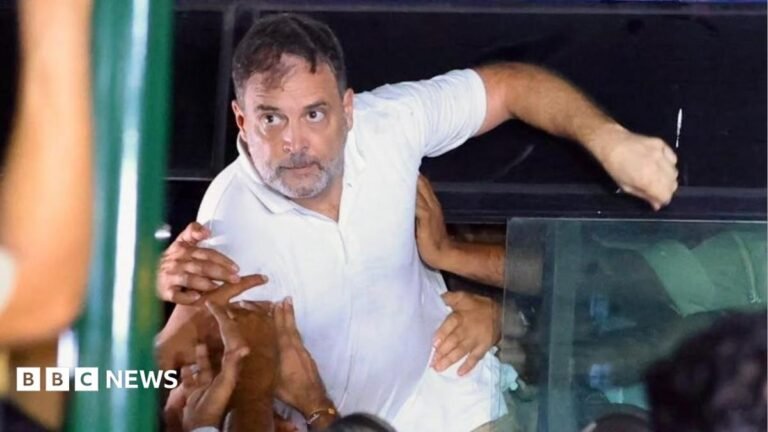 India opposition leader Rahul Gandhi trying to get out of the police van as he is pushed inside