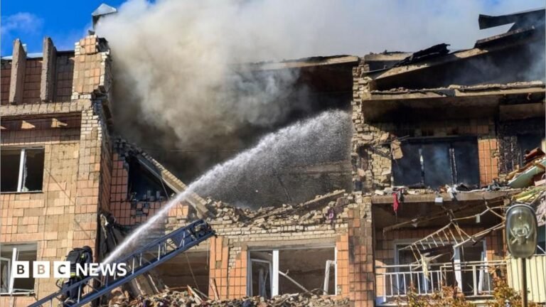 Six Ukrainian energy sites hit by Russia since Trump announced ceasefire, Zelensky says Lower half of a workman standing on a roof with a chimney visible. Some tiles are not yet laid on the roof structure.