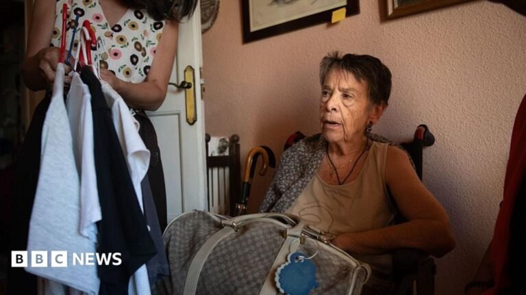 Spanish pensioner whose eviction sparked nationwide protests dies, union says Maricarmen Abascal sits in a chair in her flat ahead of her eviction, in Madrid, Spain on 23 September. She has short, dark hair and is wearing a cream vest. A holdall bag is on her lap. A woman whose face is out of shot is holding up clothes on a hanger next to Abascal.