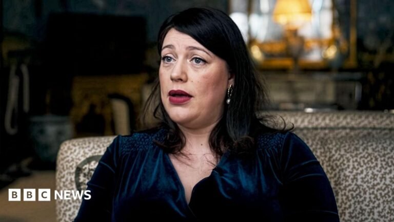 Tory MP questions government advisor’s position after wife’s Palestine Action post Somebody holding up a smart-phone in their right hand. The screen is black with 'Revolut' written in white letters.