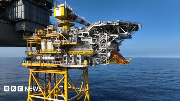UK government to make Jackdaw gas field announcement Somebody holding up a smart-phone in their right hand. The screen is black with 'Revolut' written in white letters.