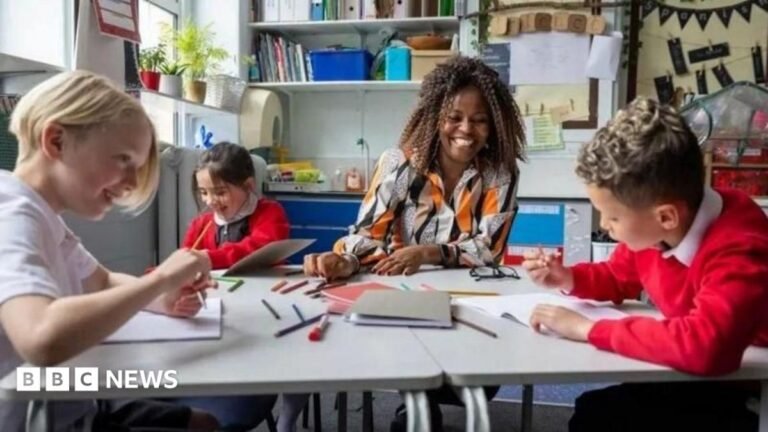 A group of children with a teacher sat at a table in a school.