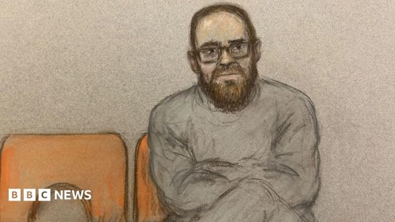 Widdecombe suspect had ‘particular hostility to Reform’, court told A court sketch of Joshua Kerry. He sits with his legs and arms crossed on an orange chair. He is wearing glasses and a grey tracksuit.