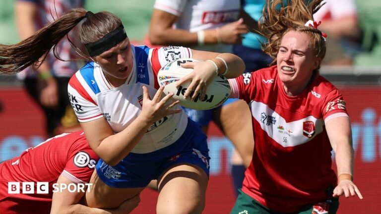 Connie Boyd holds on to the ball as two Wales players look to halt her progress